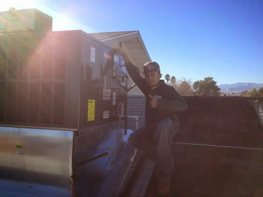 HVAC technician performing AC Tune-Up on a rooftop unit in Wahpeton